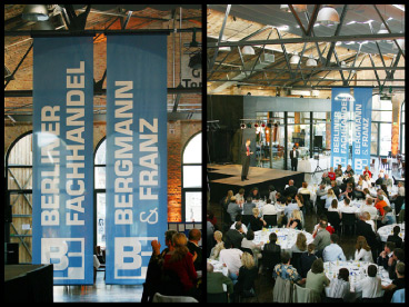 Fotos von Veranstaltung
in der schicken Halle eines fabrikartigen Altbaus, Nahaufnahme von den zwei
neuen Logos als von der Decke hängenden Fahnen